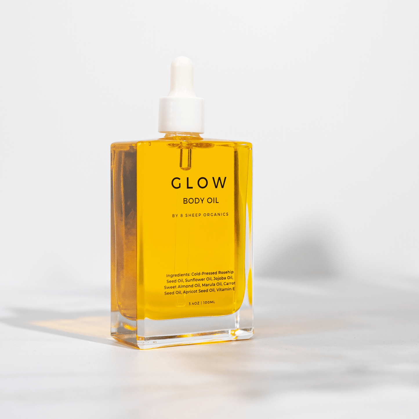 Bottle of 'GLOW' body oil on a white background