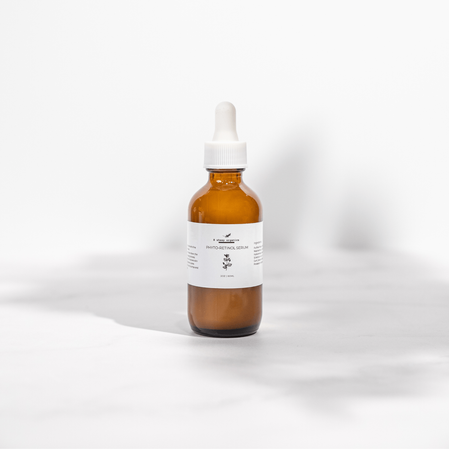 Amber glass dropper bottle with a white label on a light gray background