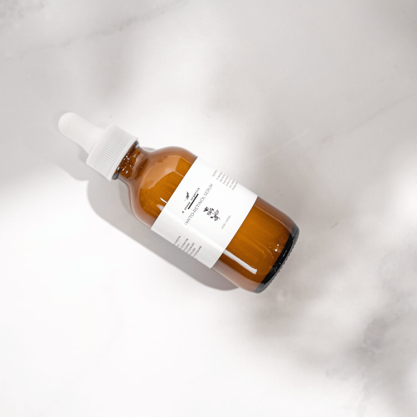 Amber glass dropper bottle with a white label on a light gray background