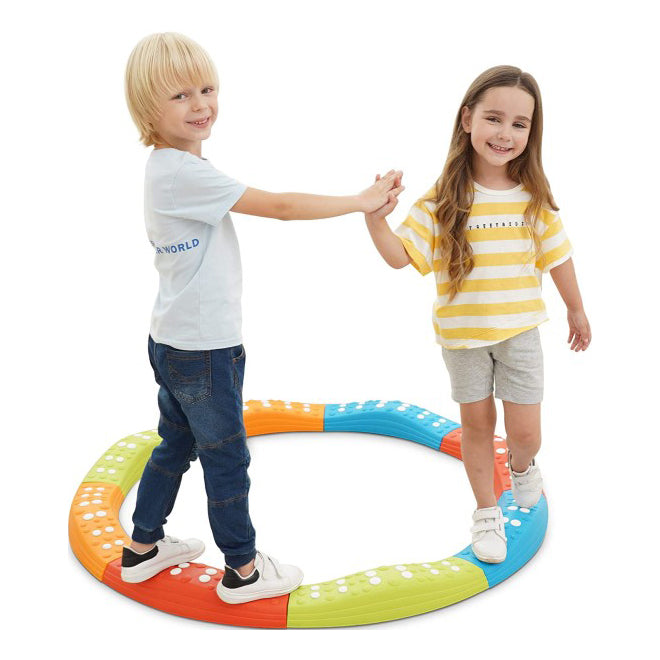 Two children standing on a colorful play mat with a white background