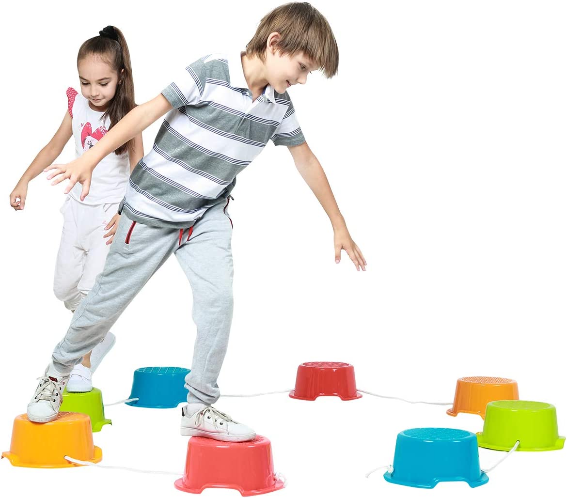 Two children playing with colorful stepping stones on a white background