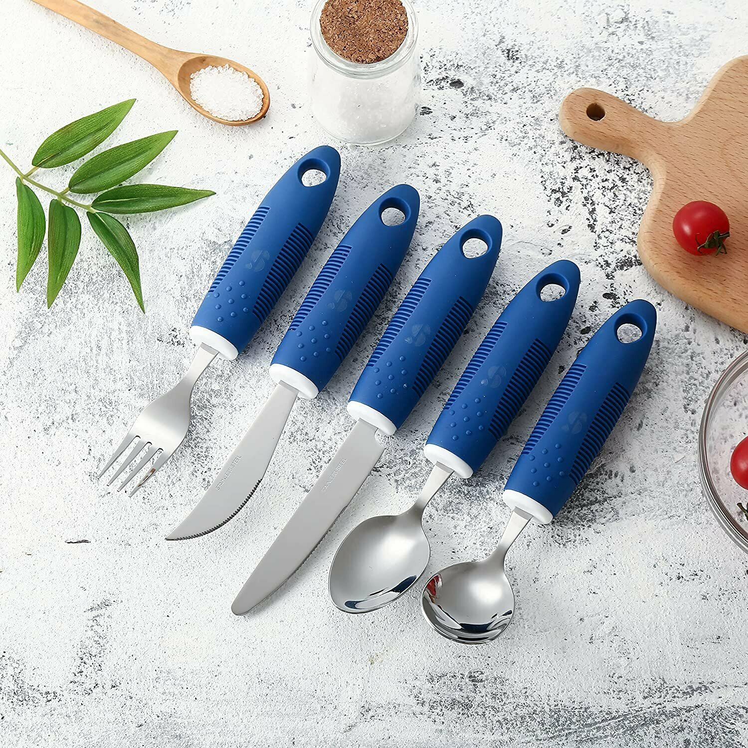 Set of blue-handled cutlery including knives and spoons on a textured surface with kitchen items.