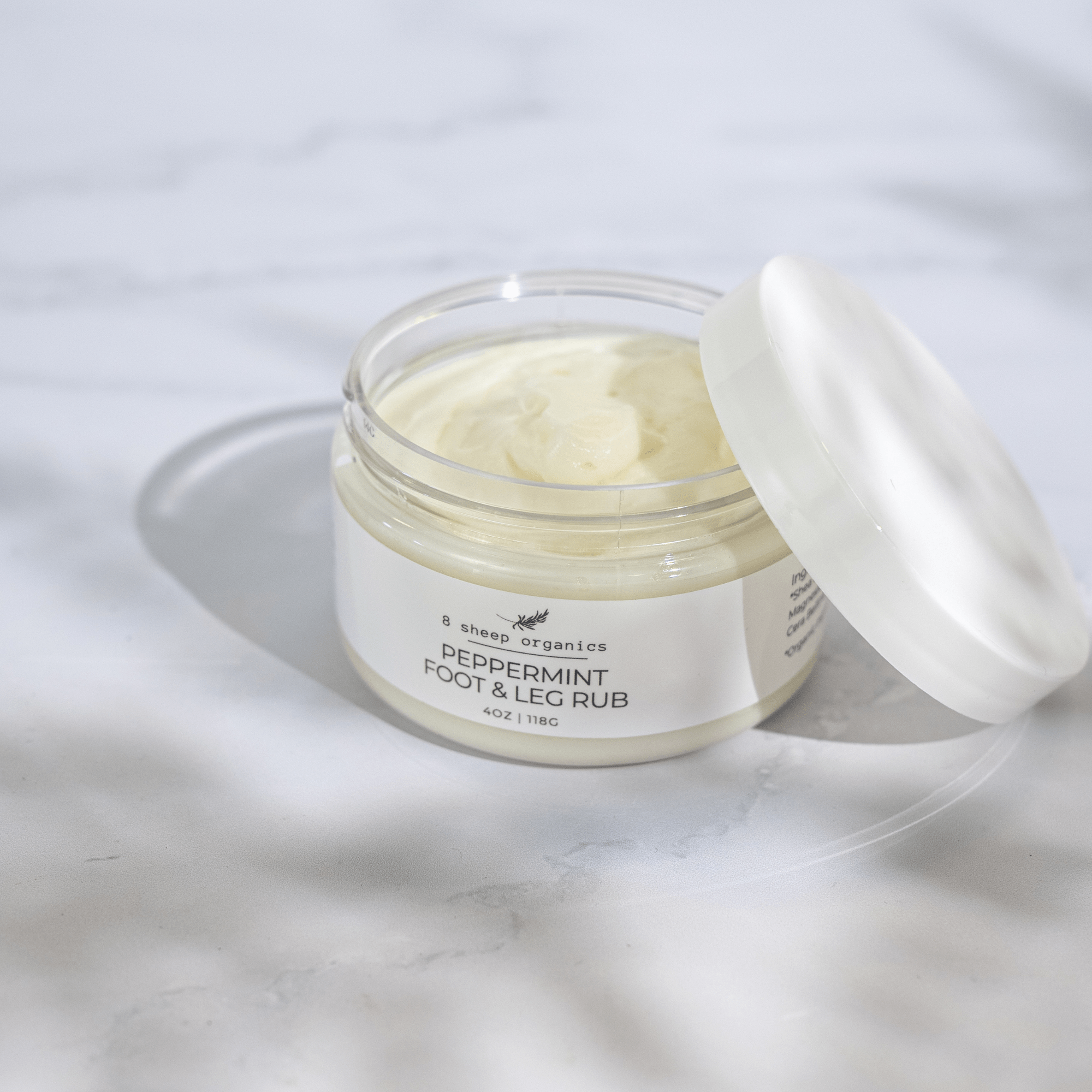 Jar of peppermint foot and leg rub on a white background