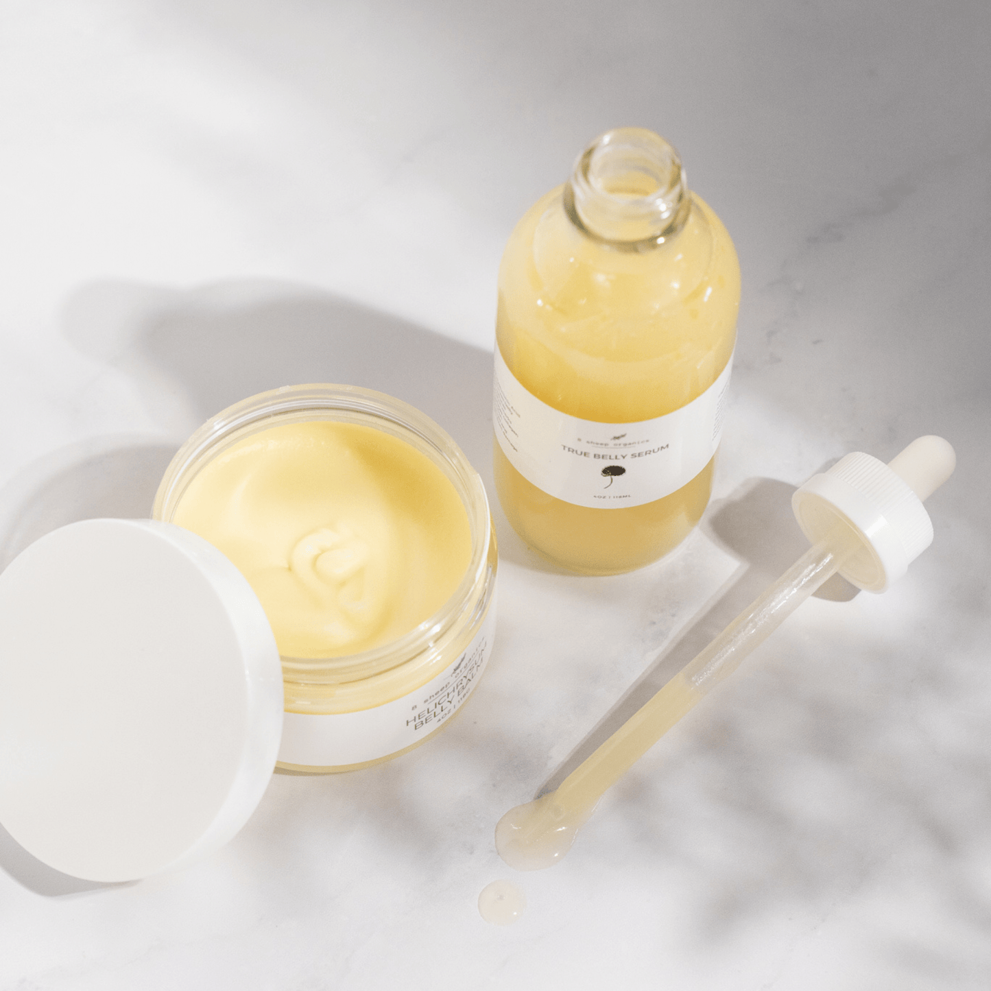 Skincare products including a jar, bottle, and dropper on a light background