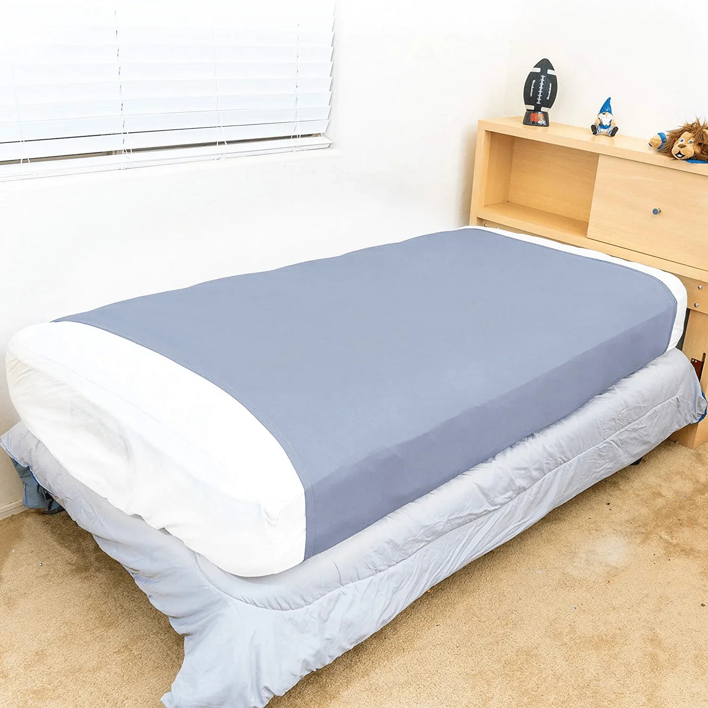 Light blue sensory bed sheet on twin bed in a child's room, calming sleep support.