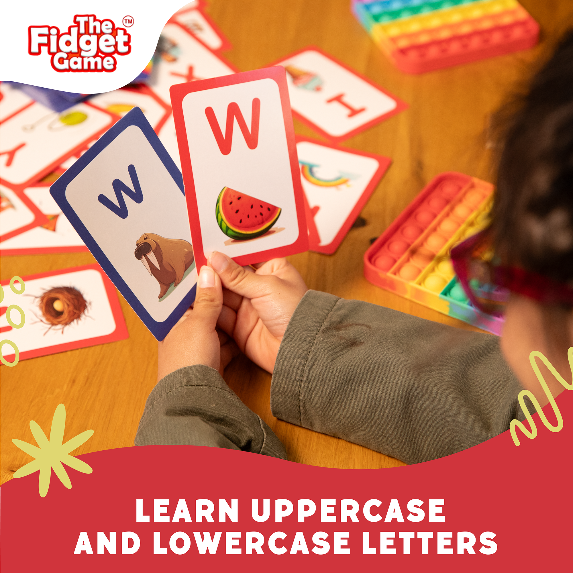 Child playing with educational cards featuring letters and images on a wooden table.