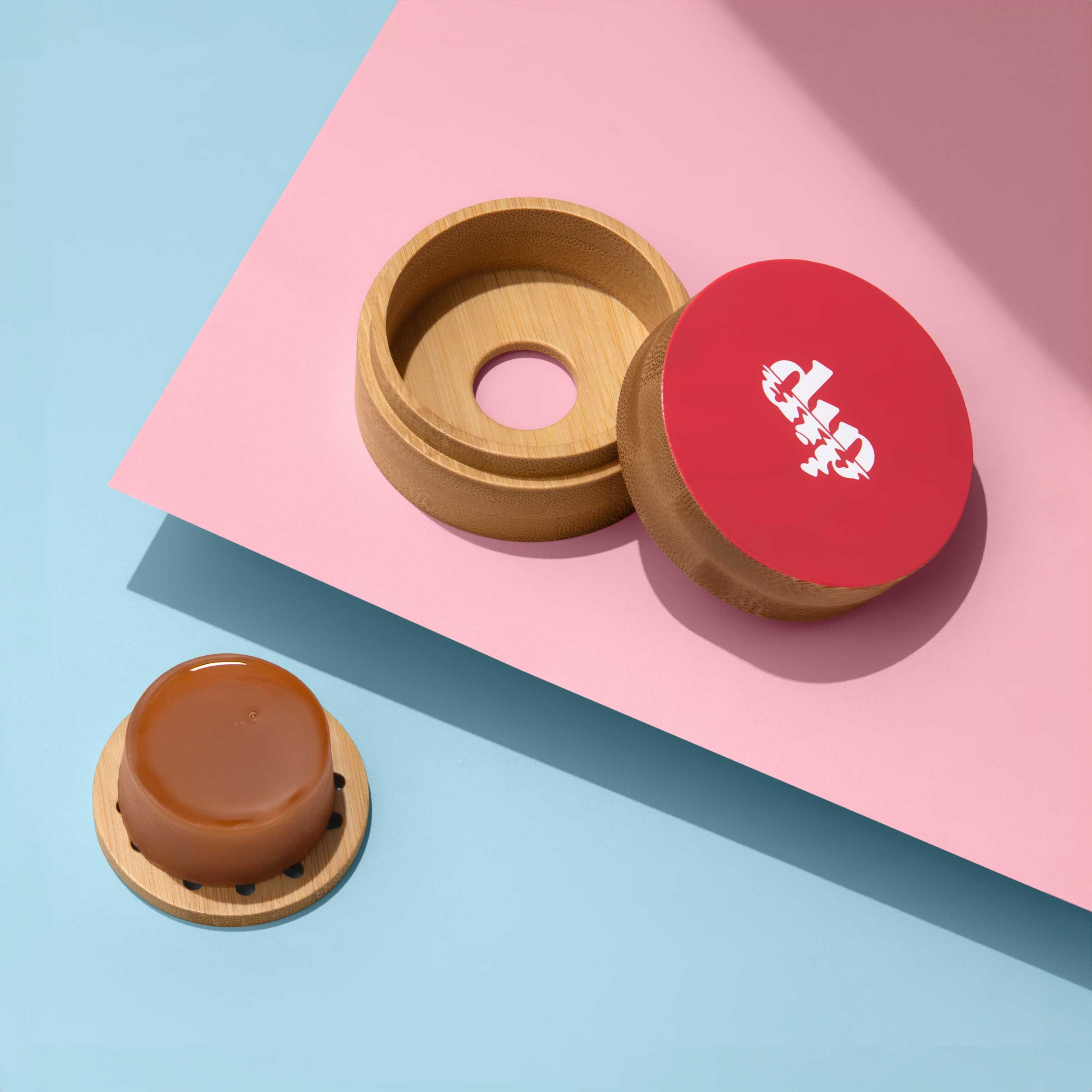 Wooden and red containers with a brand logo on a pink and blue background