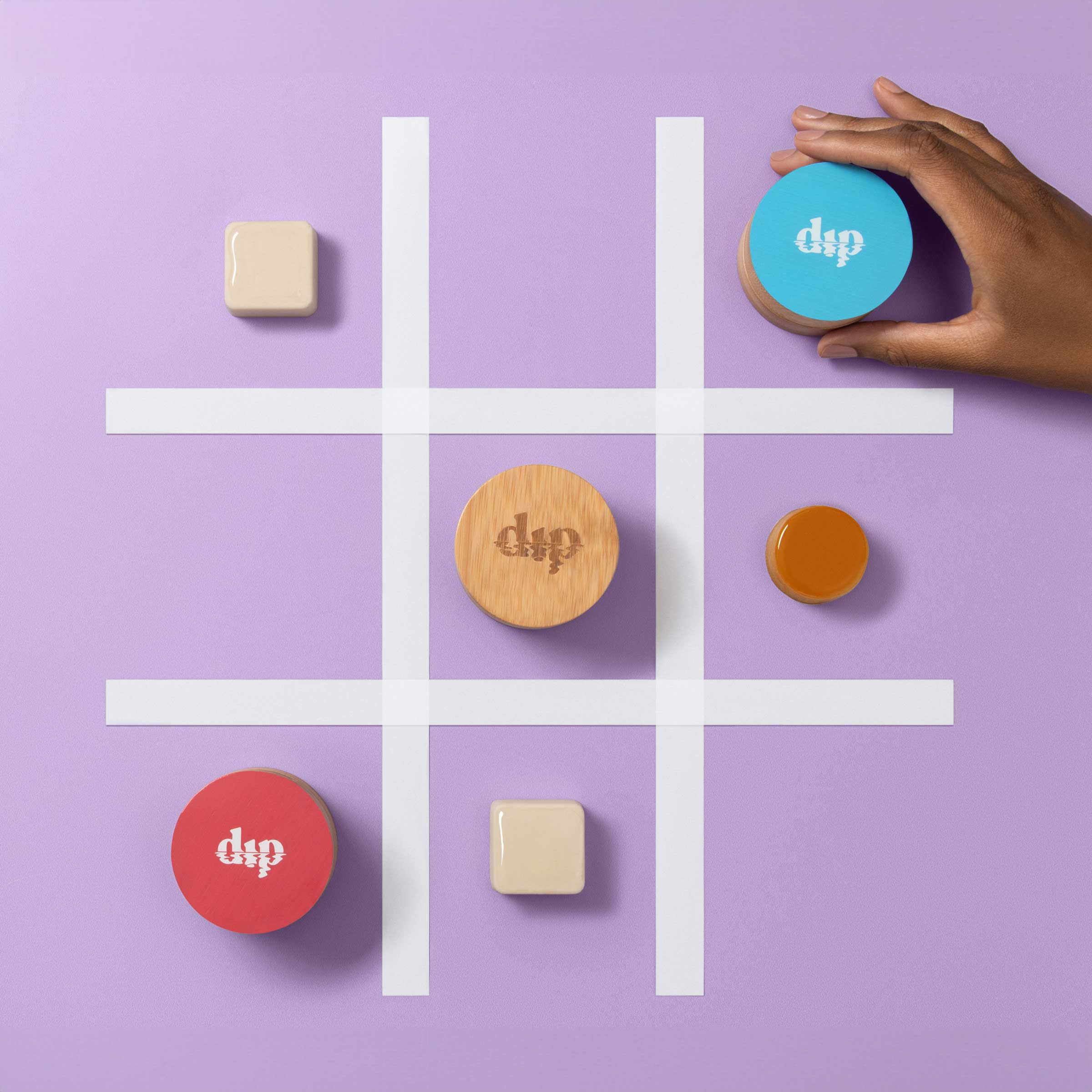 Tic-tac-toe game with colorful game pieces on a purple background