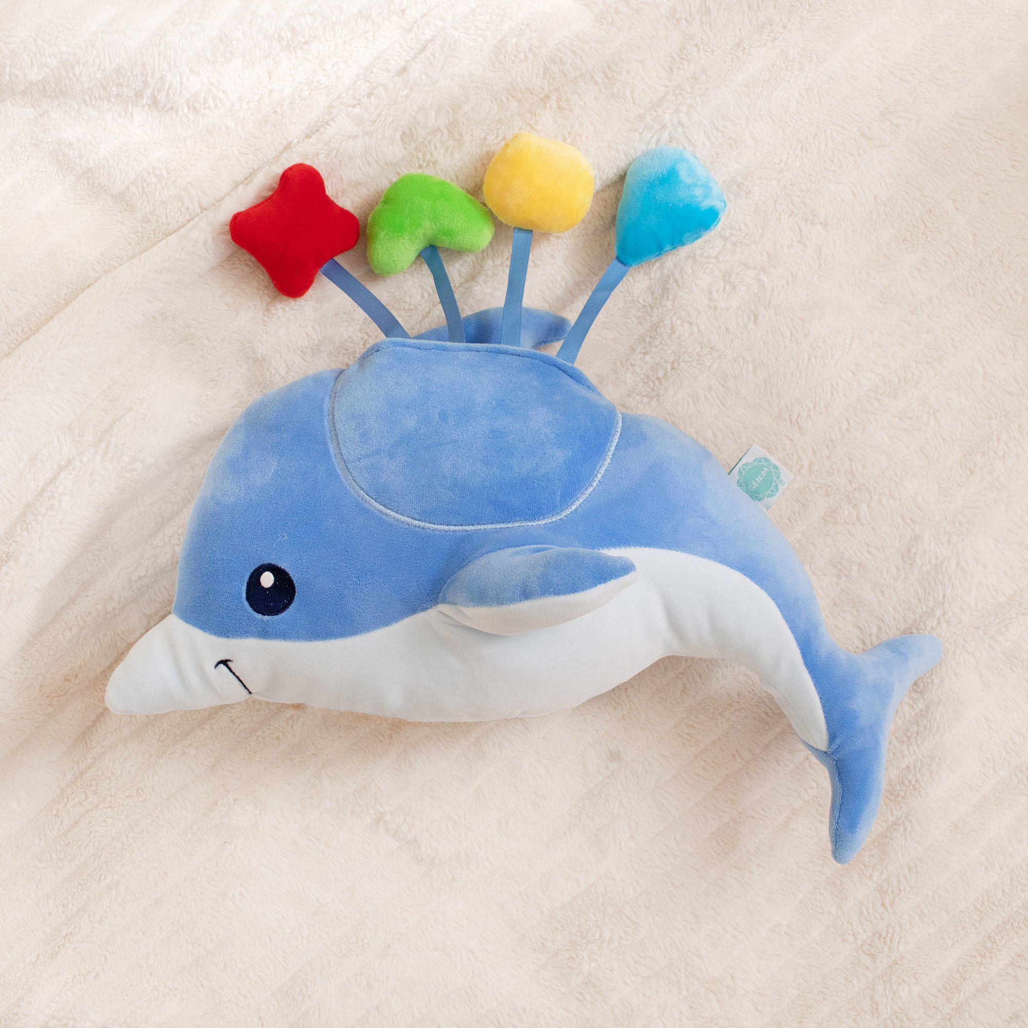 Blue dolphin plush toy on a beige blanket