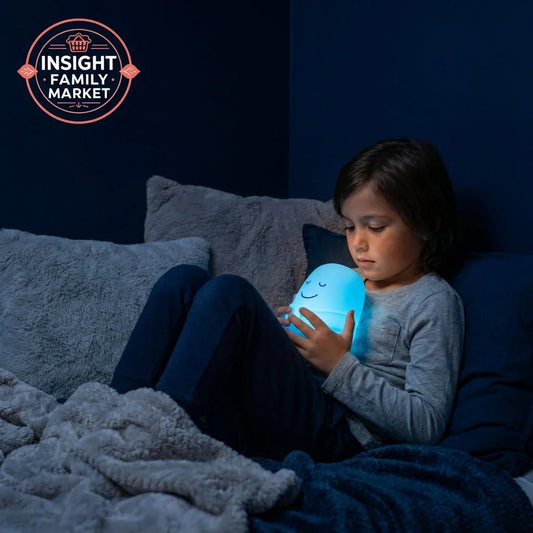 Child holding glowing sensory night light in cozy bedroom, calming aid for sleep support