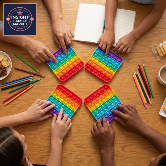 Children playing with rainbow-colored pop-it toys on a wooden table.