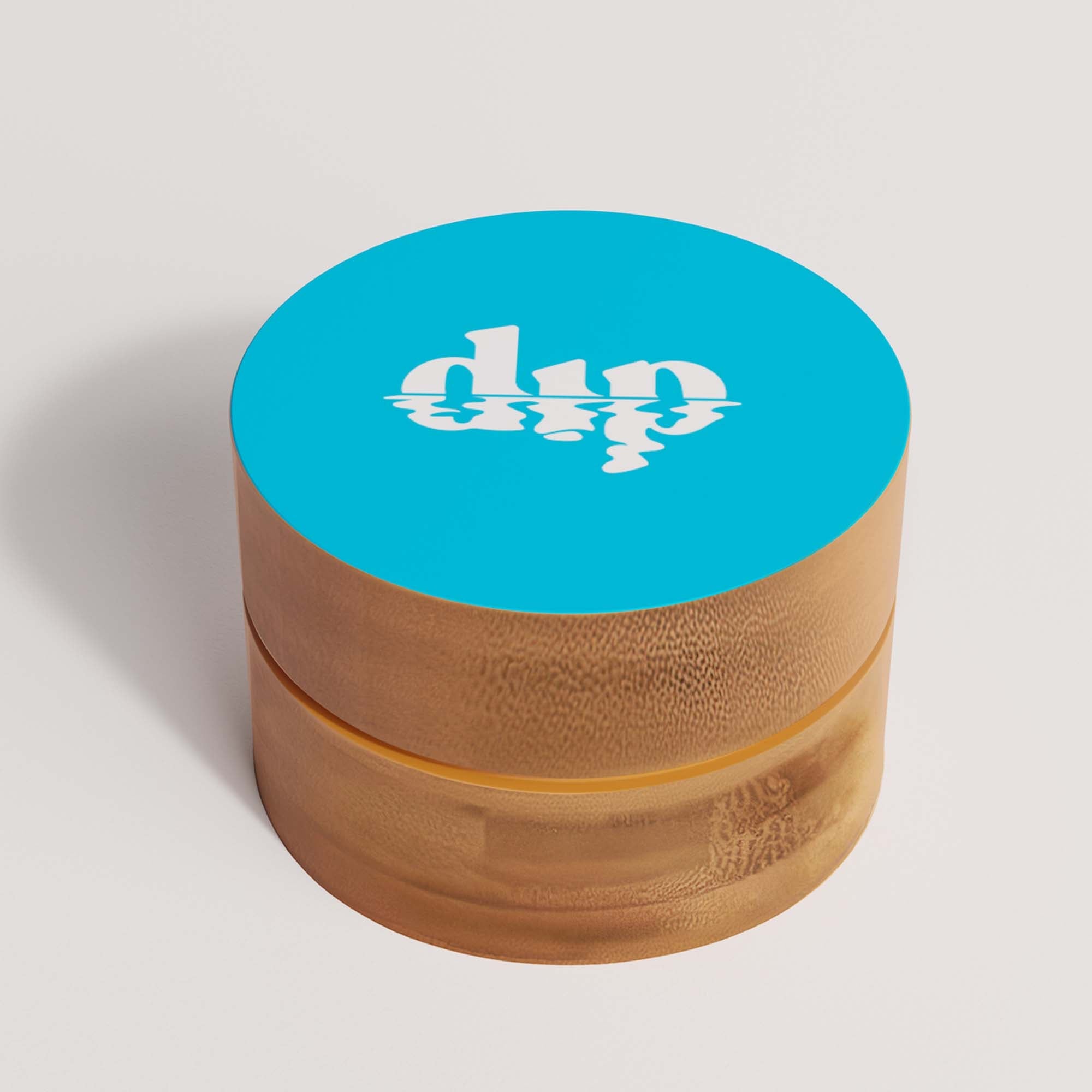 Wooden grinder with blue top and 'dip' logo on a light gray background