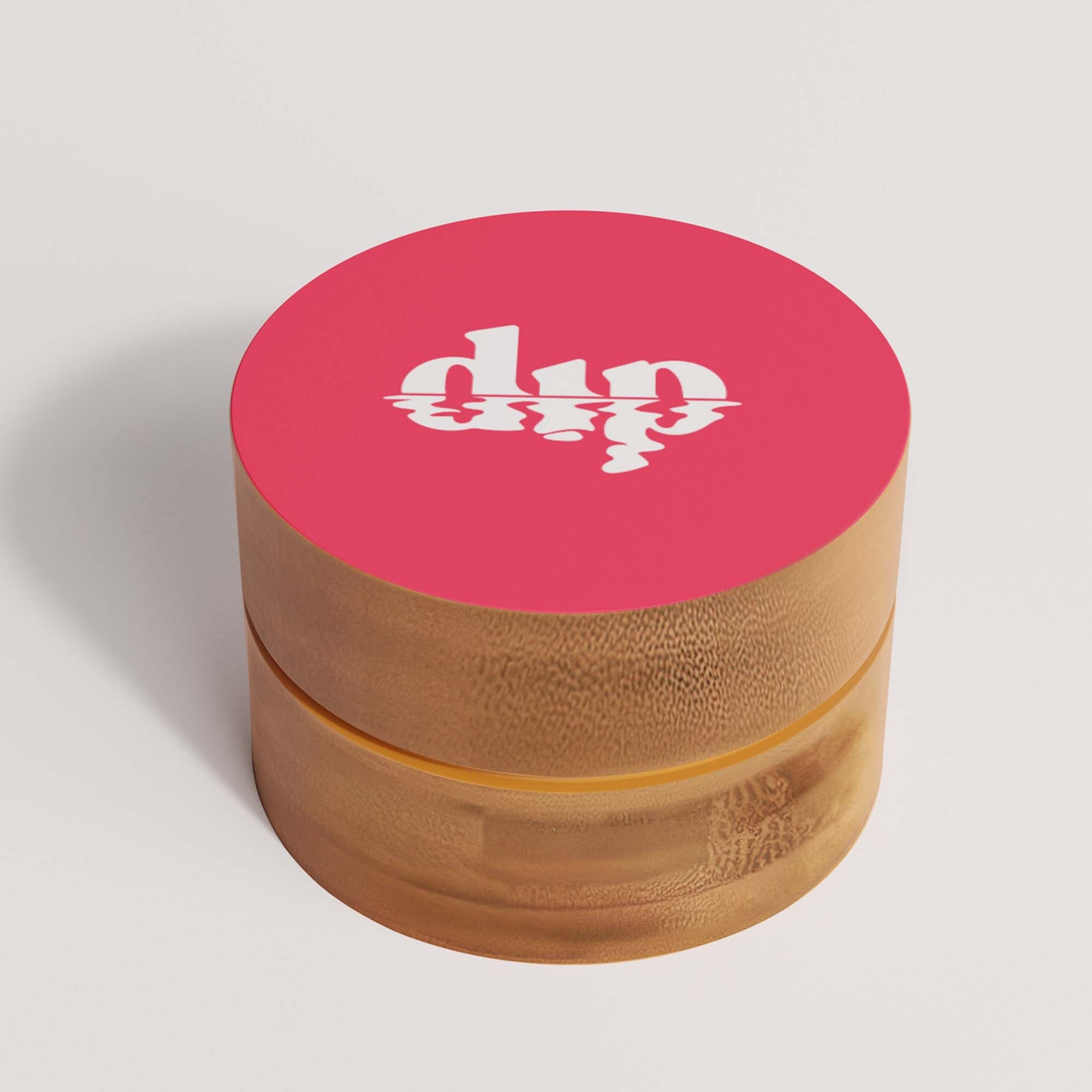 Wooden grinder with pink top and 'dip' logo on a light gray background