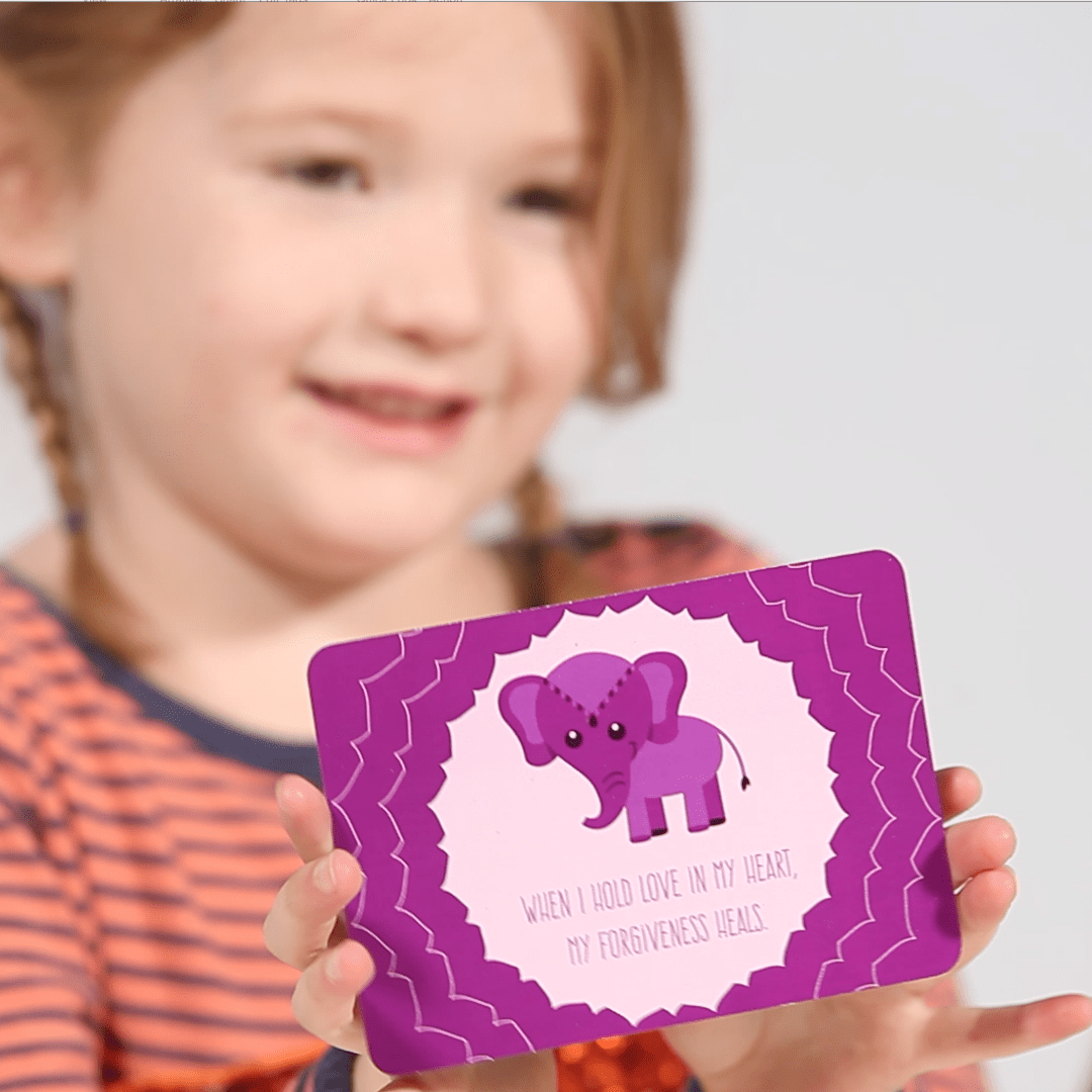 Child holding a purple card with an elephant illustration and text.