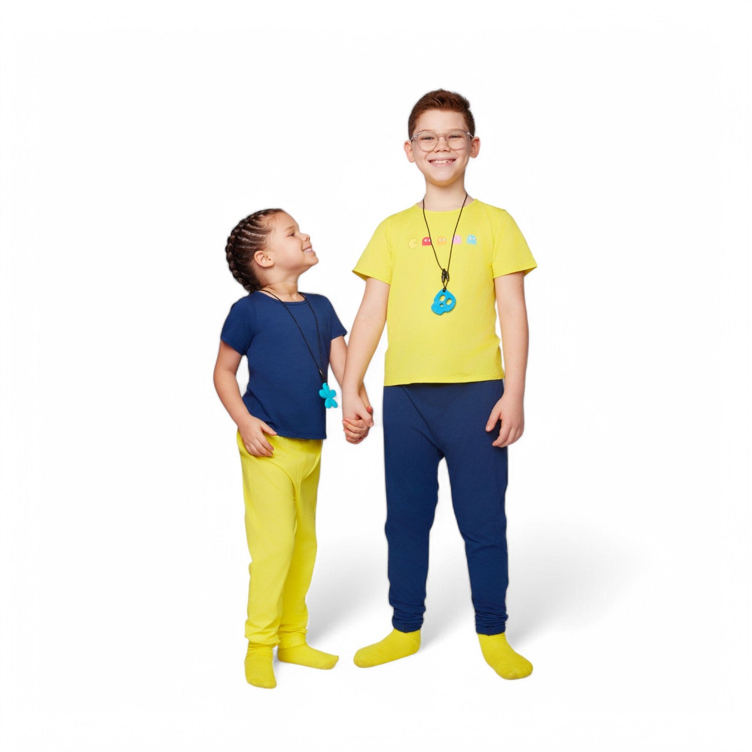 Two children wearing matching pajama sets with a white background