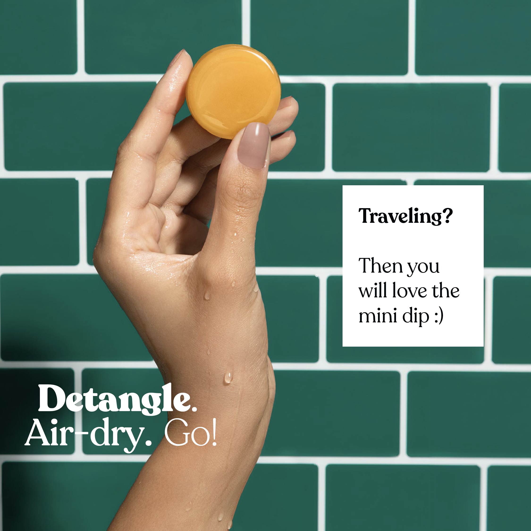 Hand holding a small round object with text on a green tiled background