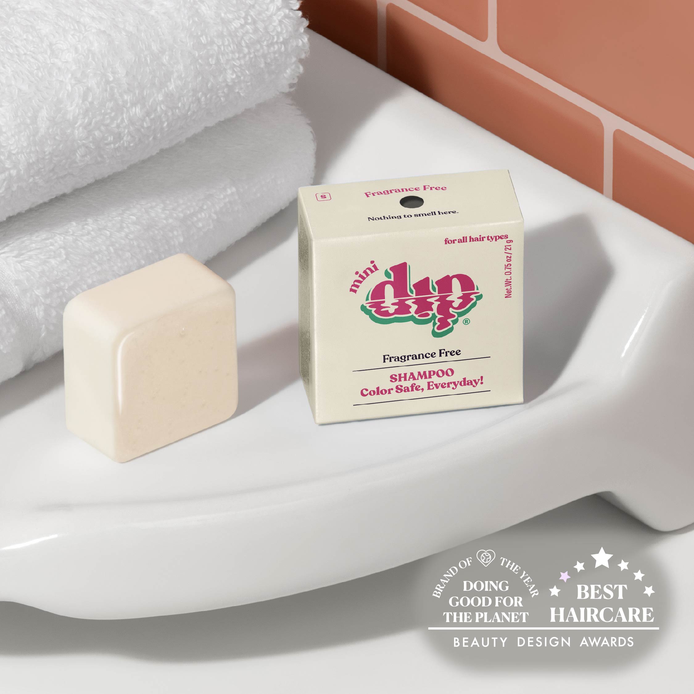 Bar of soap and box of 'dip' shampoo on a bathroom counter with awards text.