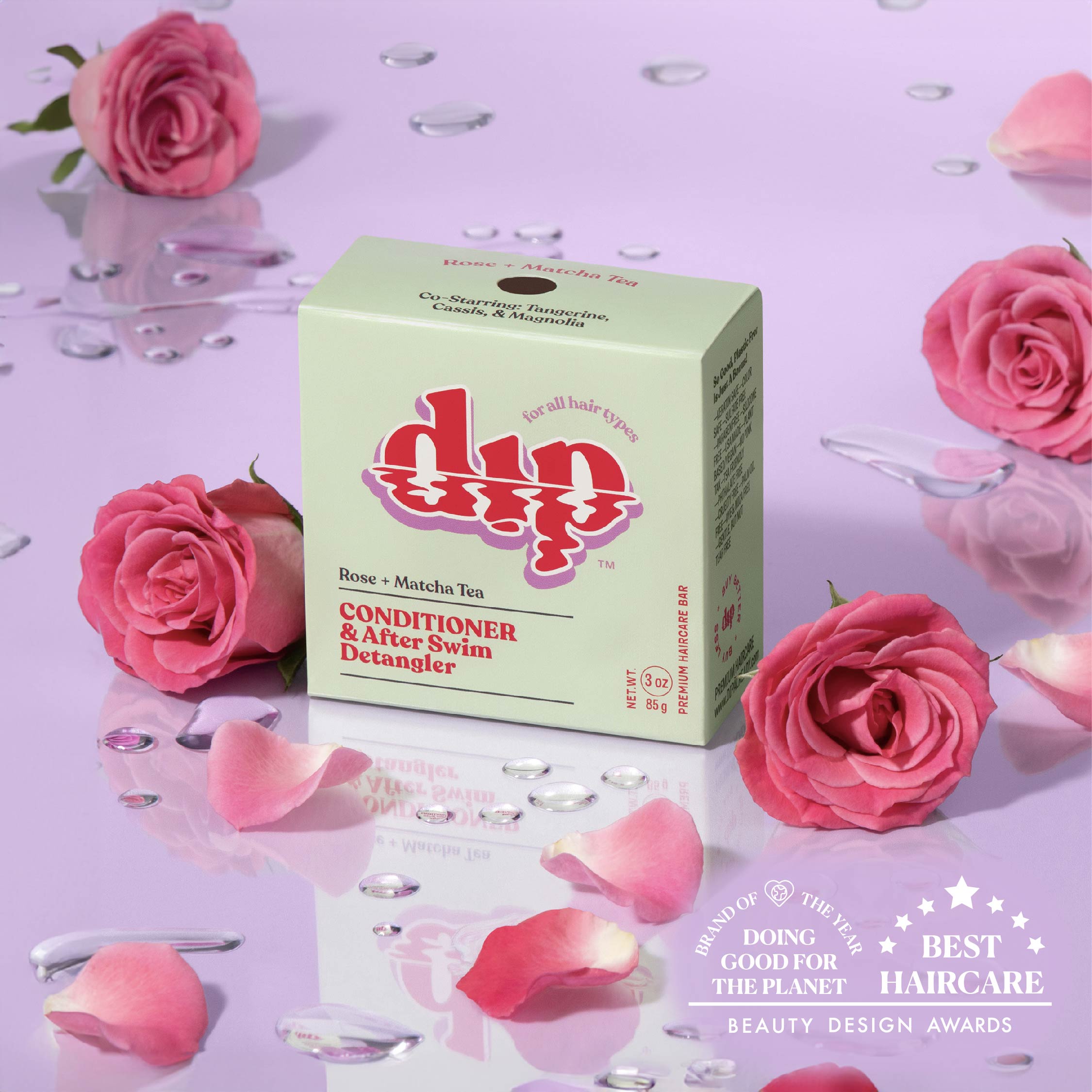 Box of 'dip' conditioner with pink roses and rose petals on a purple background