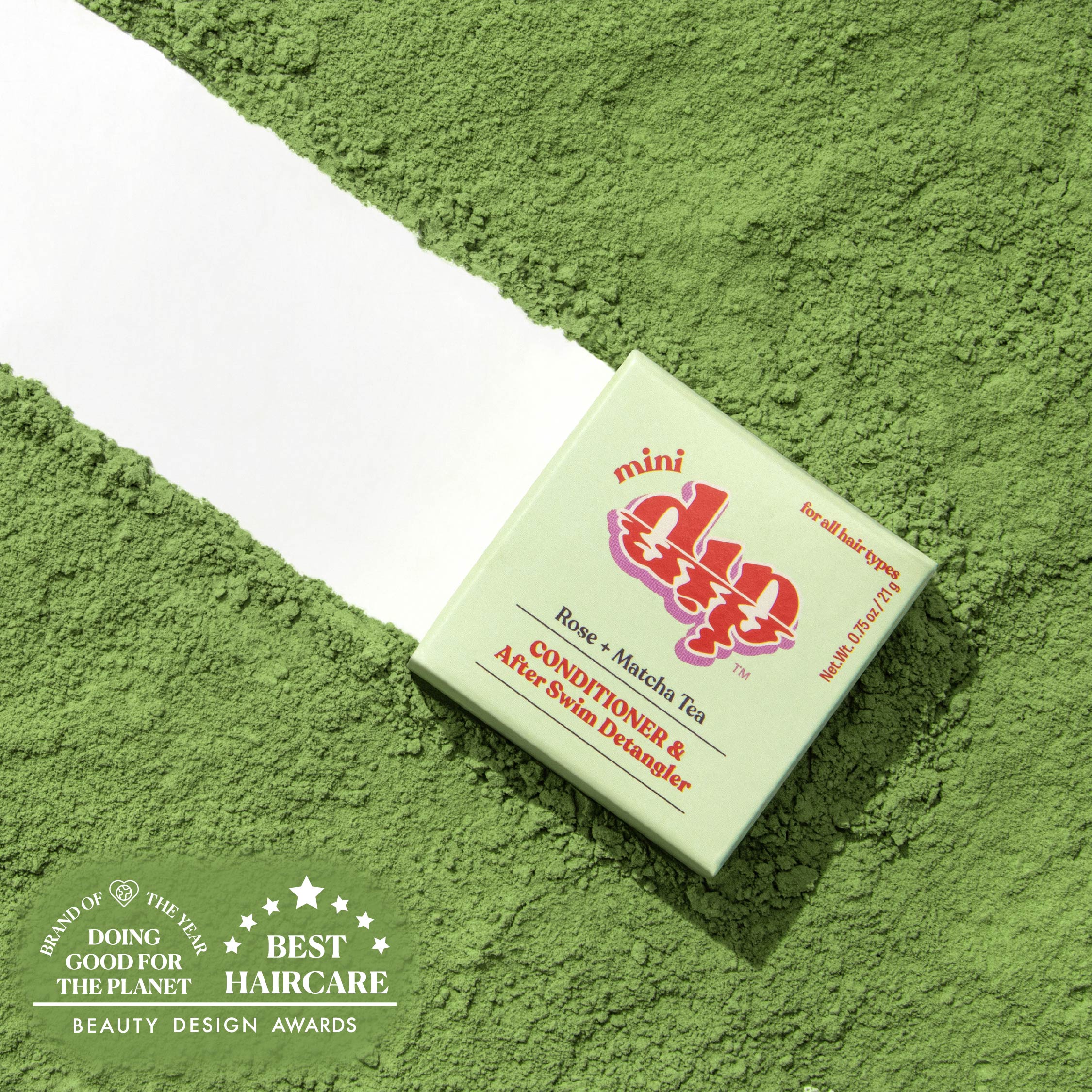 Green box of a hair care product on a green textured background with awards text.