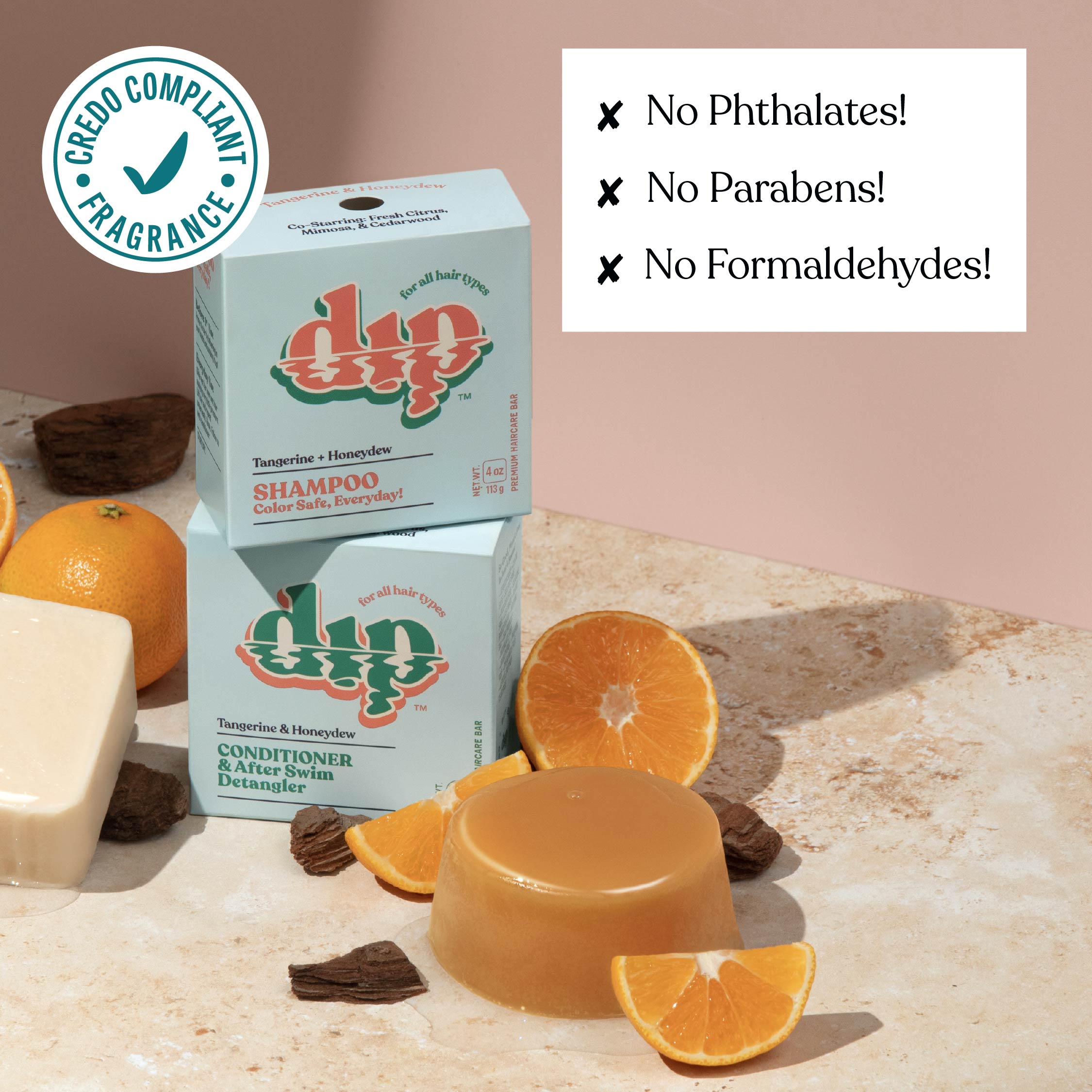 Dip shampoo and conditioner bars with oranges and soap on a stone surface, featuring a Credio Compliant Fragrance badge.