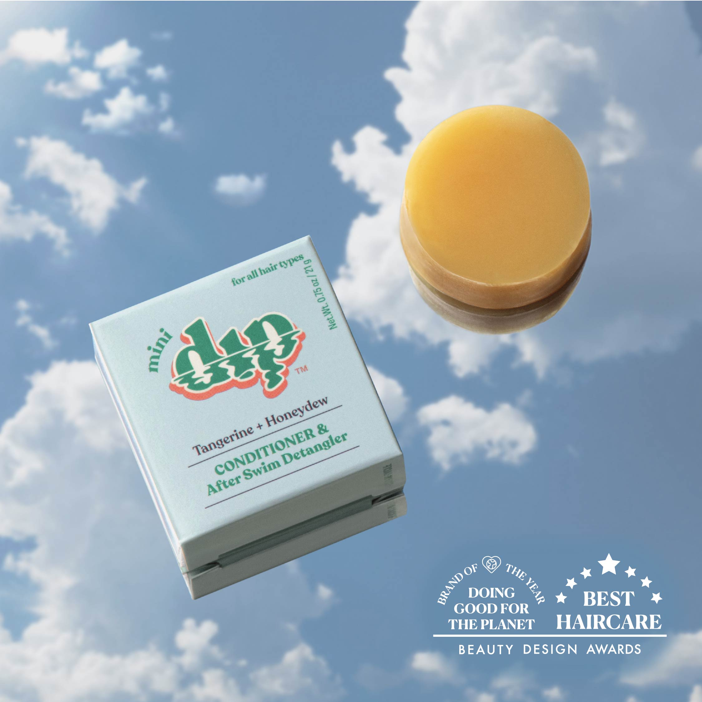 Box of 'mini dip' hair care product with a yellow bar of soap against a cloudy sky background.