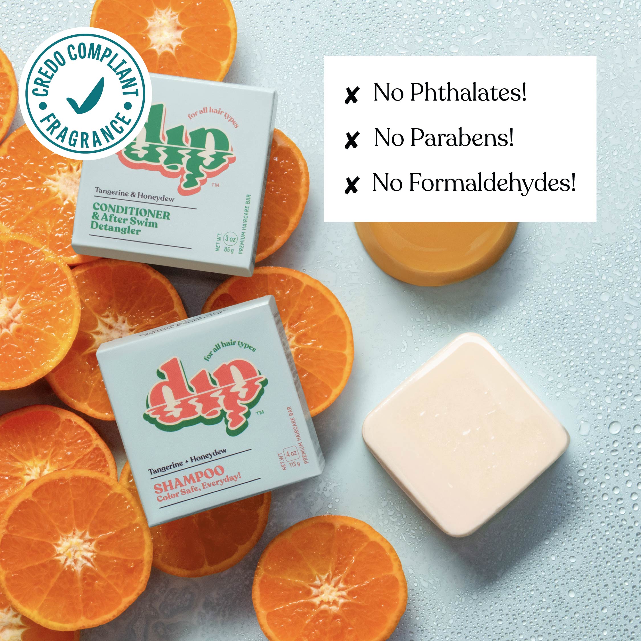 Dip shampoo and conditioner bars with orange slices on a light blue background