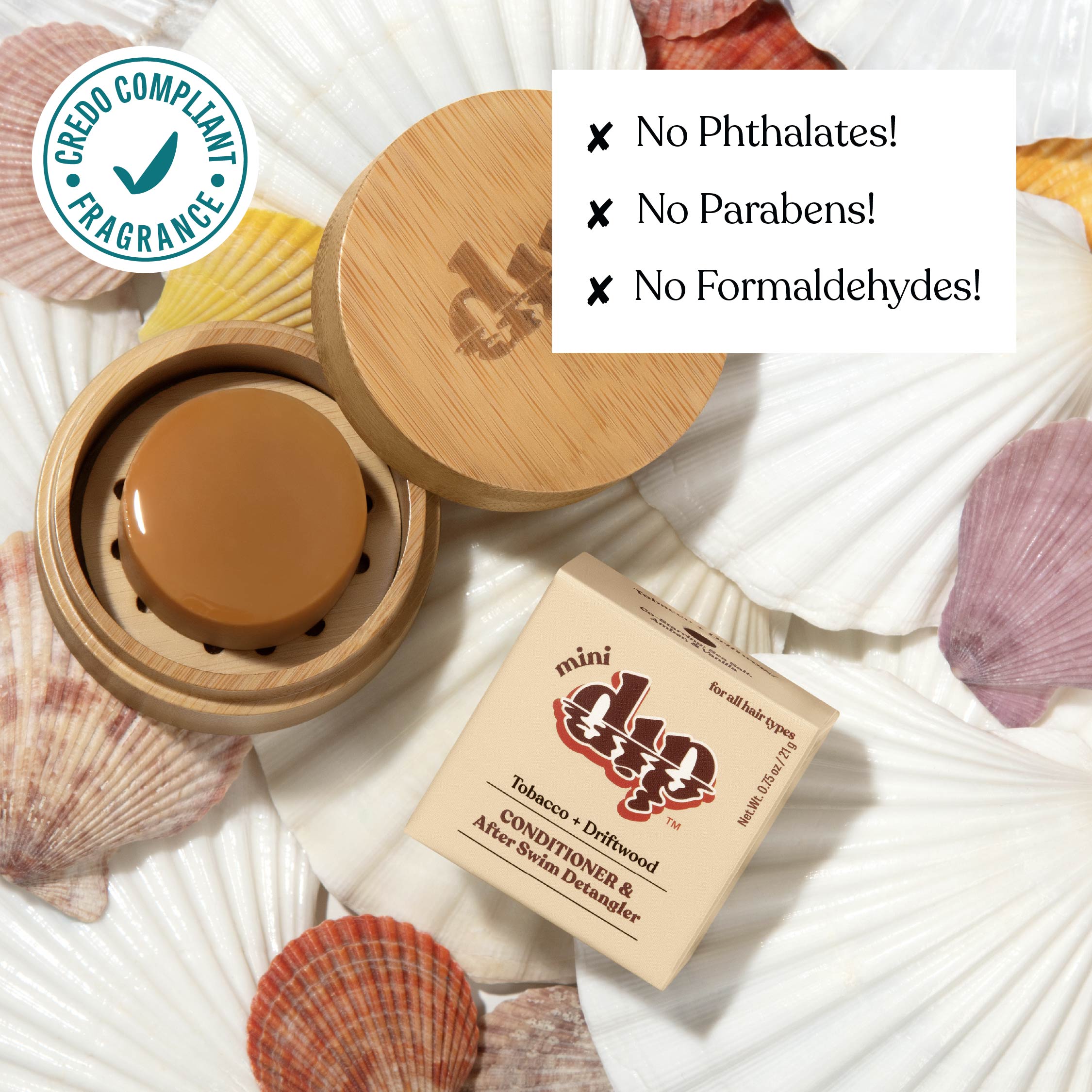 Cosmetic product with wooden lid and packaging on seashells, featuring green label and text about product ingredients.