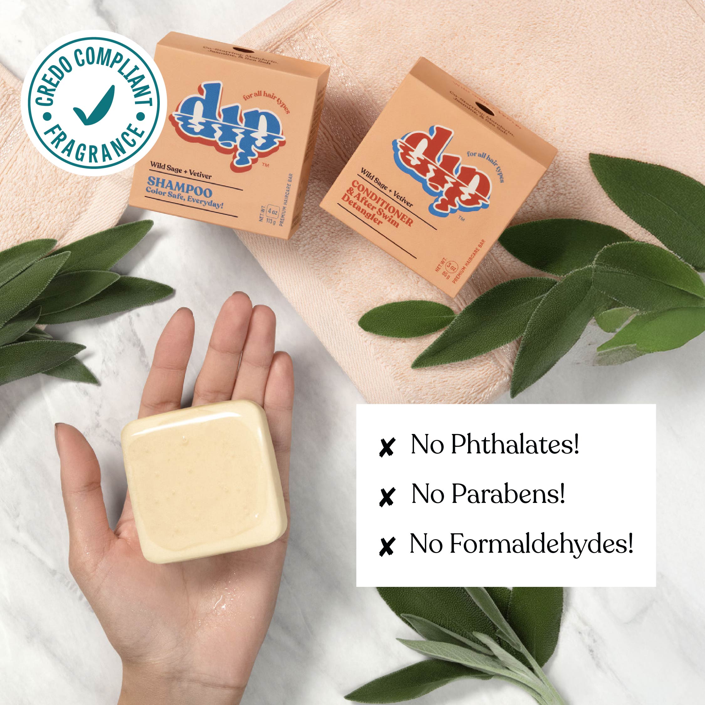 Bar of soap held in a hand with Dap Dap shampoo and conditioner boxes, green leaves, and Cruelty Free logo.
