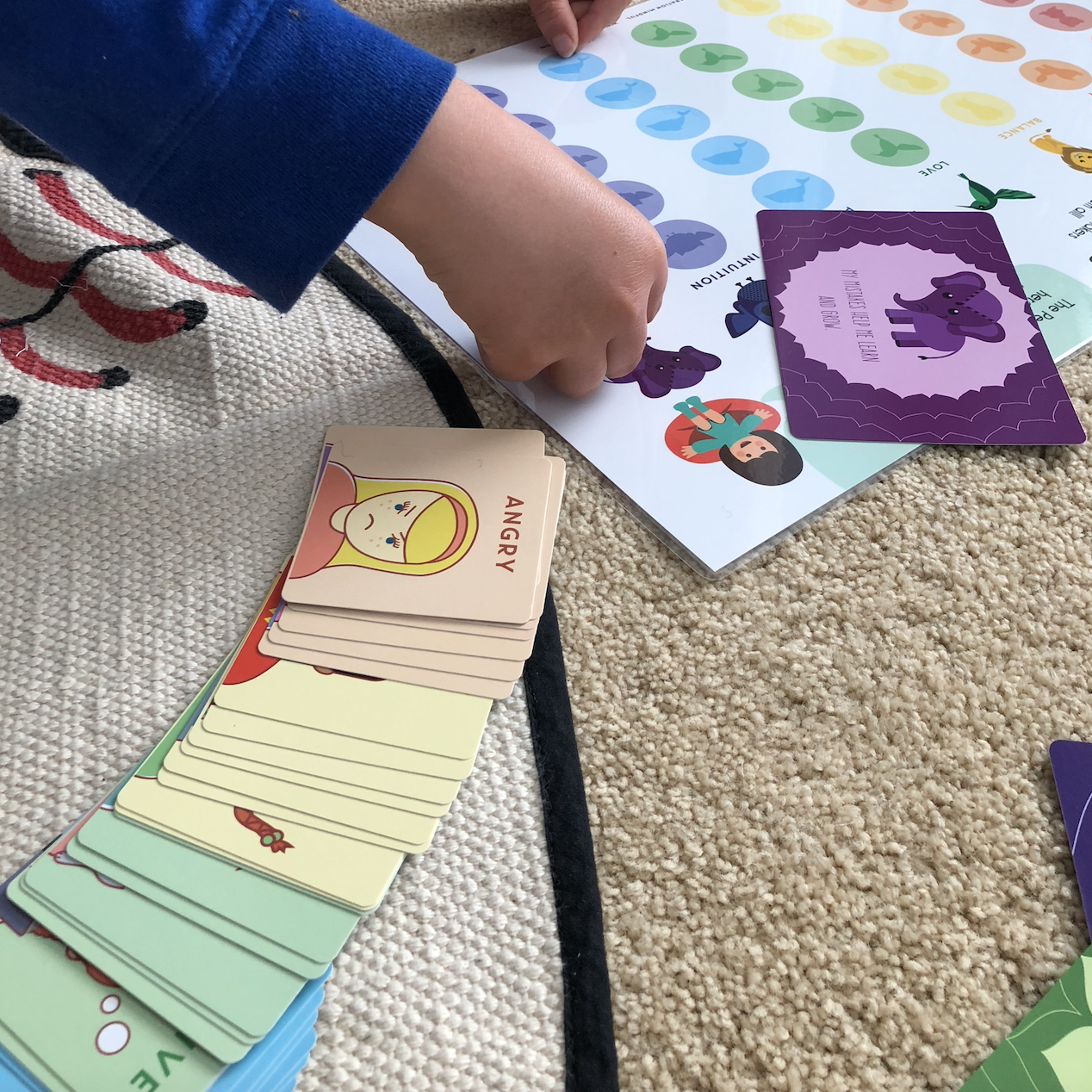 Child playing with cards on a carpeted floor