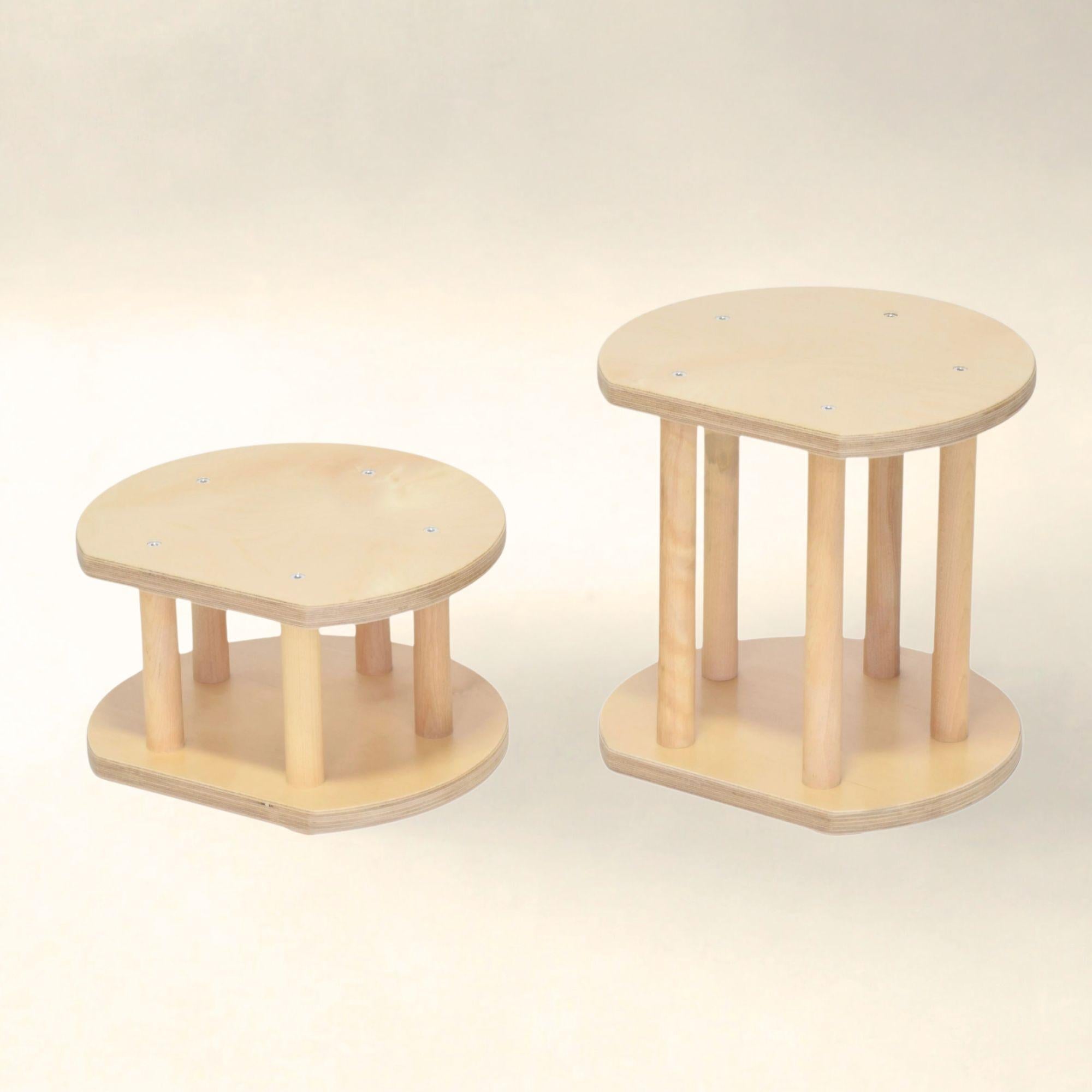 Two wooden step stools on a light background