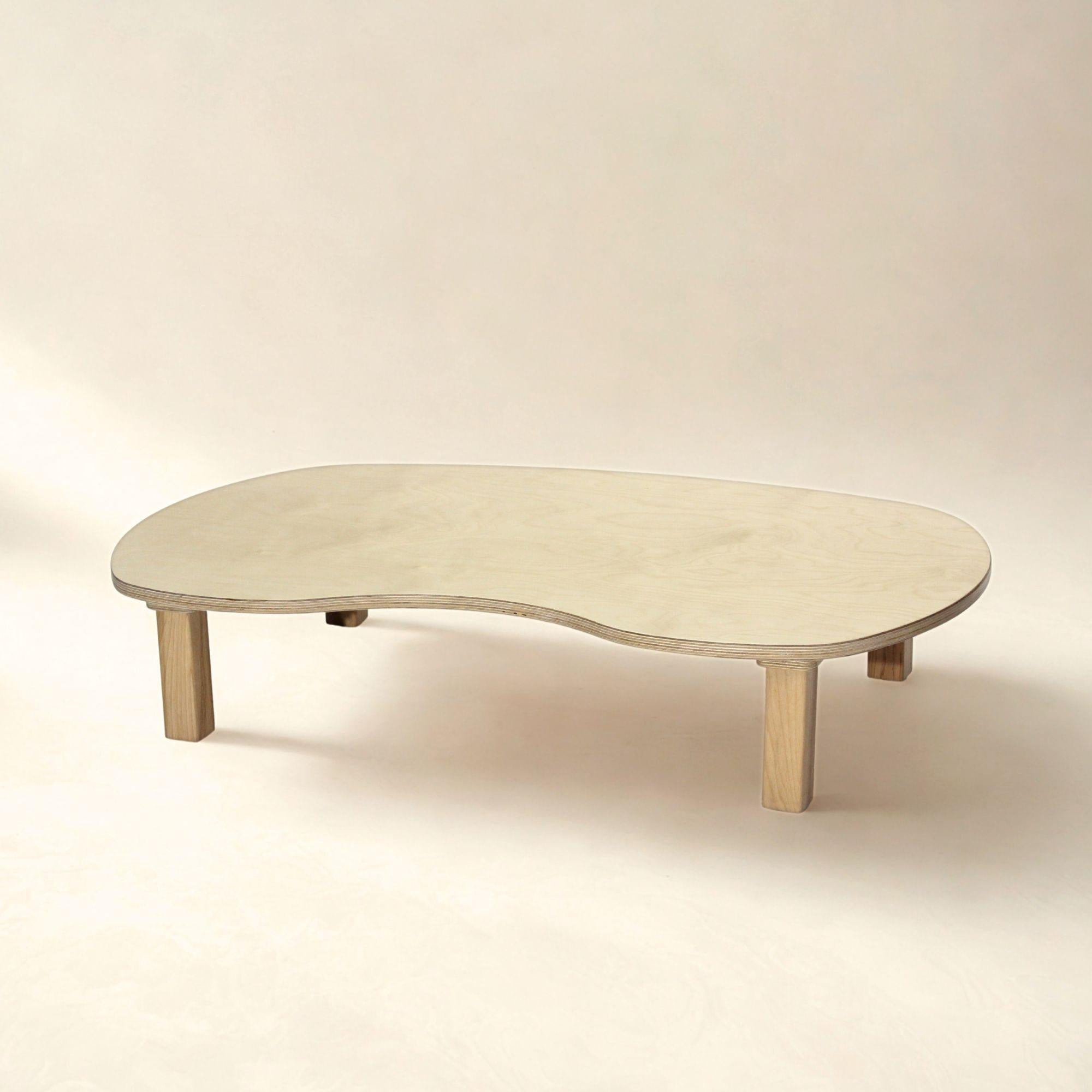 Beige coffee table with a curved design on a beige background