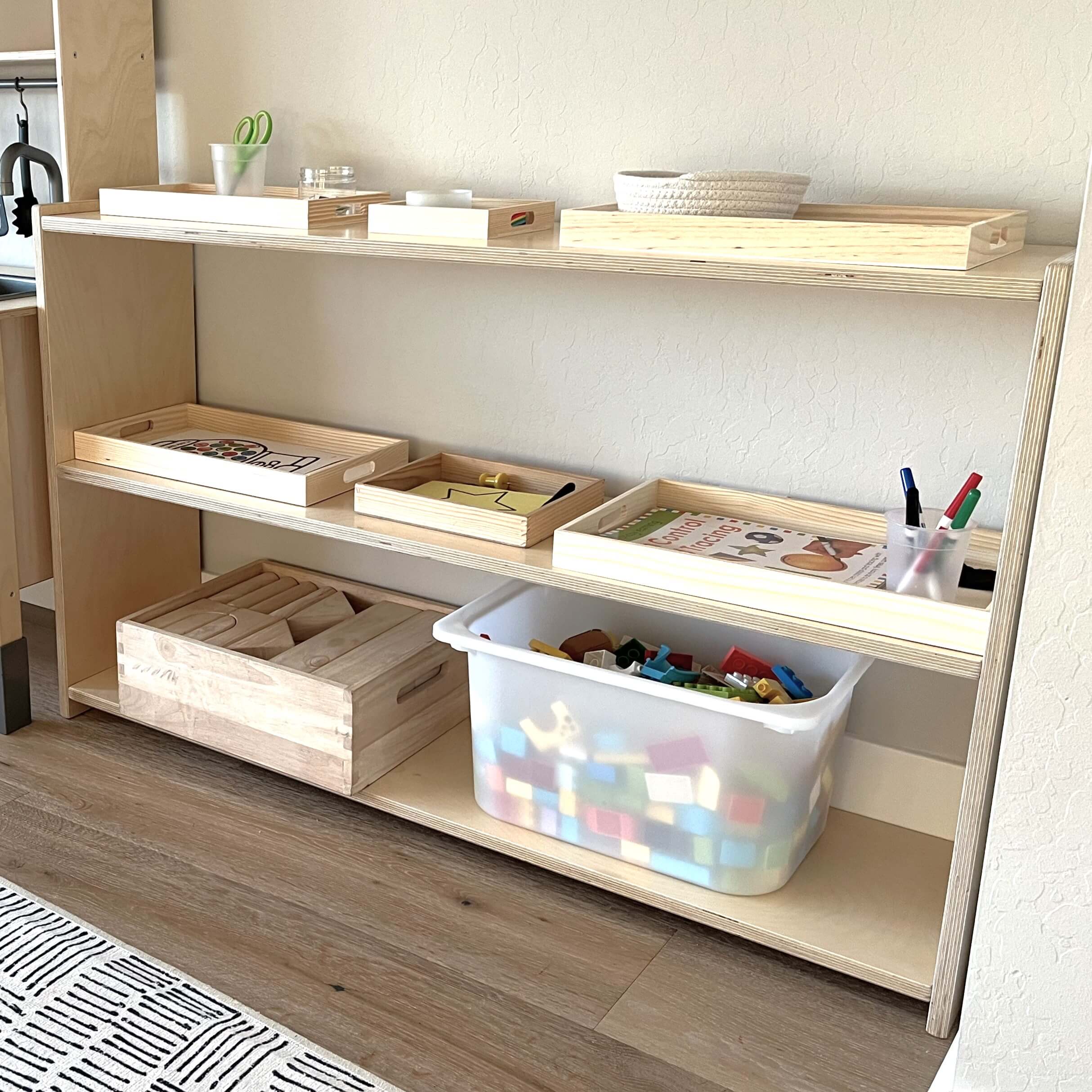 Wooden shelves with storage bins and children's toys in a room setting.