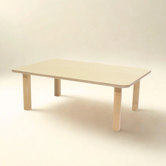 Rectangular light wood toddler table with rounded corners on neutral background