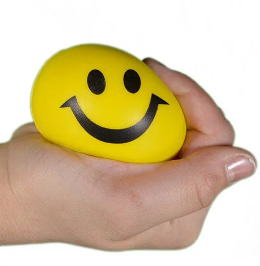 Hand squeezing yellow happy face stress ball for sensory and anxiety relief
