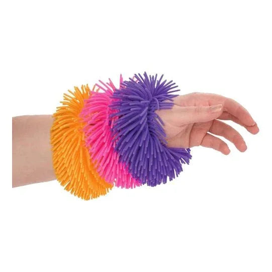 Hand wearing purple, pink, and orange sensory fidget bracelets with soft spikes