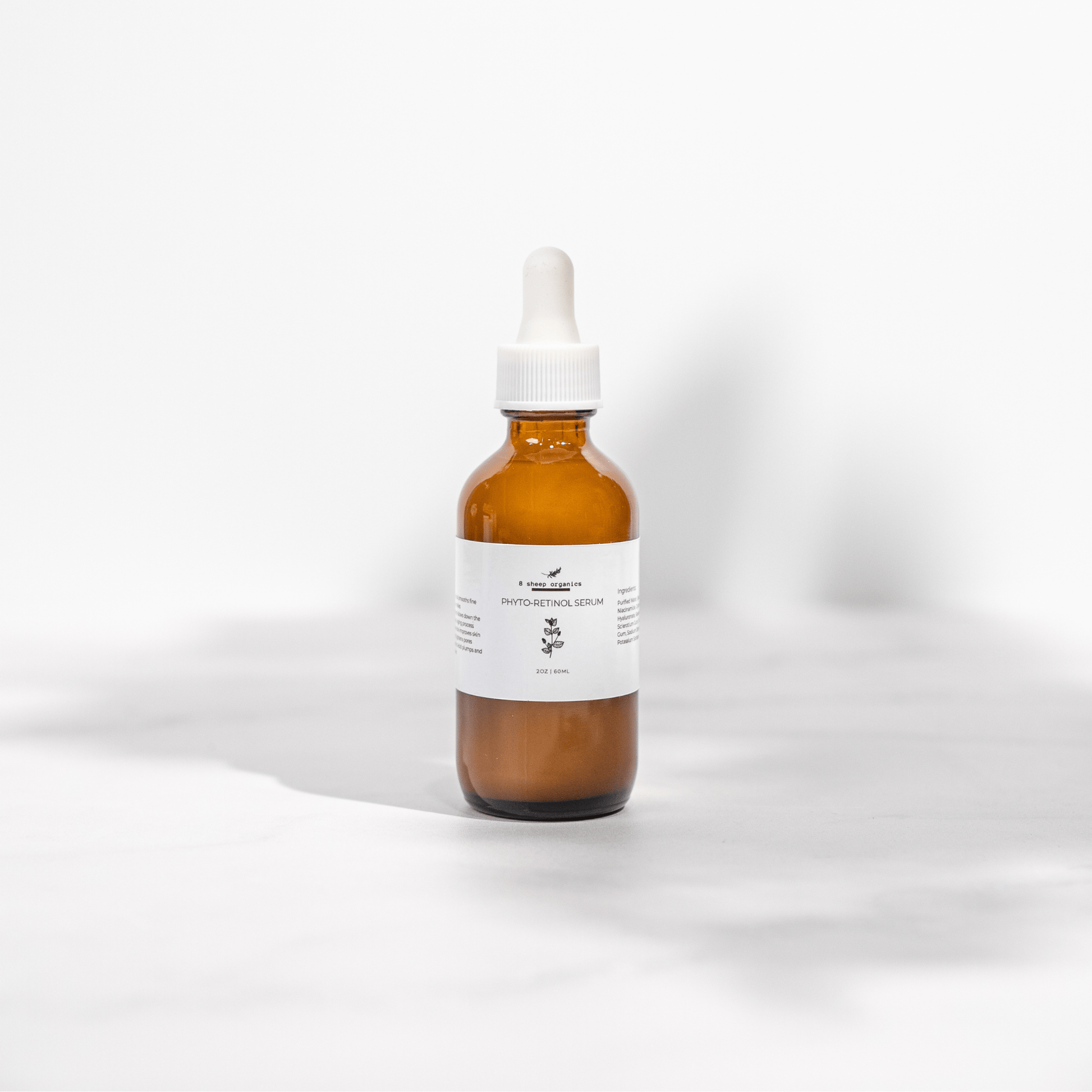 Amber glass dropper bottle with a white label on a light gray background