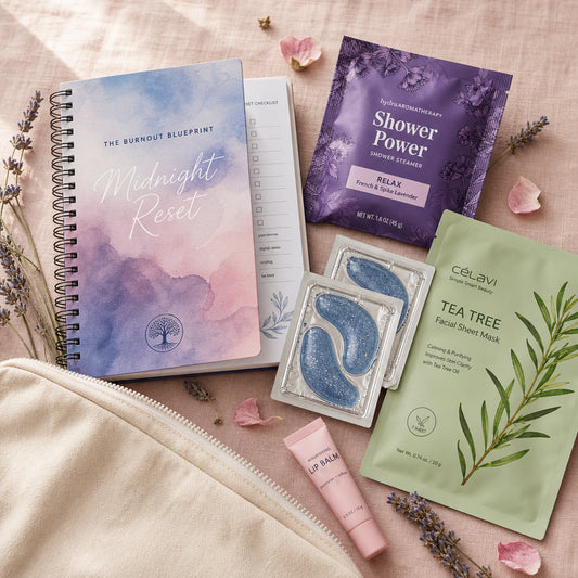 The Burnout Break Welcome Kit contents on blush linen — Midnight Reset 90-Day Journal, lavender shower steamer, blue glitter collagen eye masks, tea tree facial sheet mask, and hydrating lip butter arranged with a natural canvas pouch and dried lavender sprigs