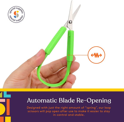 Hand holding green loop scissors with automatic blade re-opening feature for sensory-friendly use.