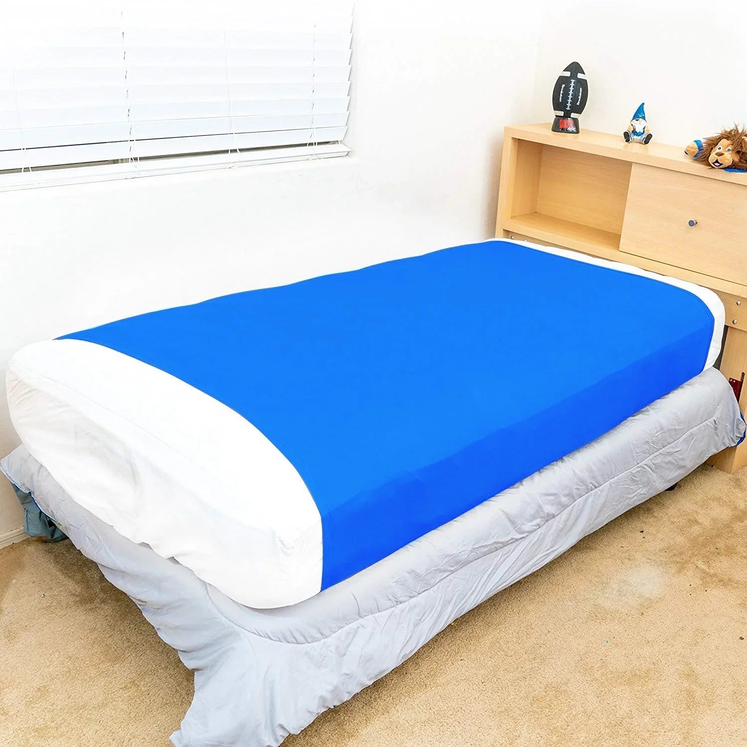 Blue sensory compression sheet on a twin bed in a child's bedroom