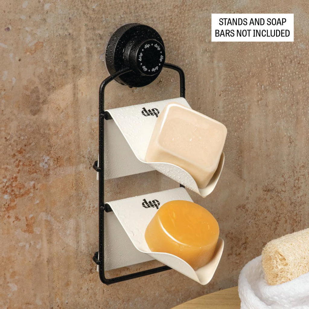 Wall-mounted soap holder with two soap bars on a textured wall background