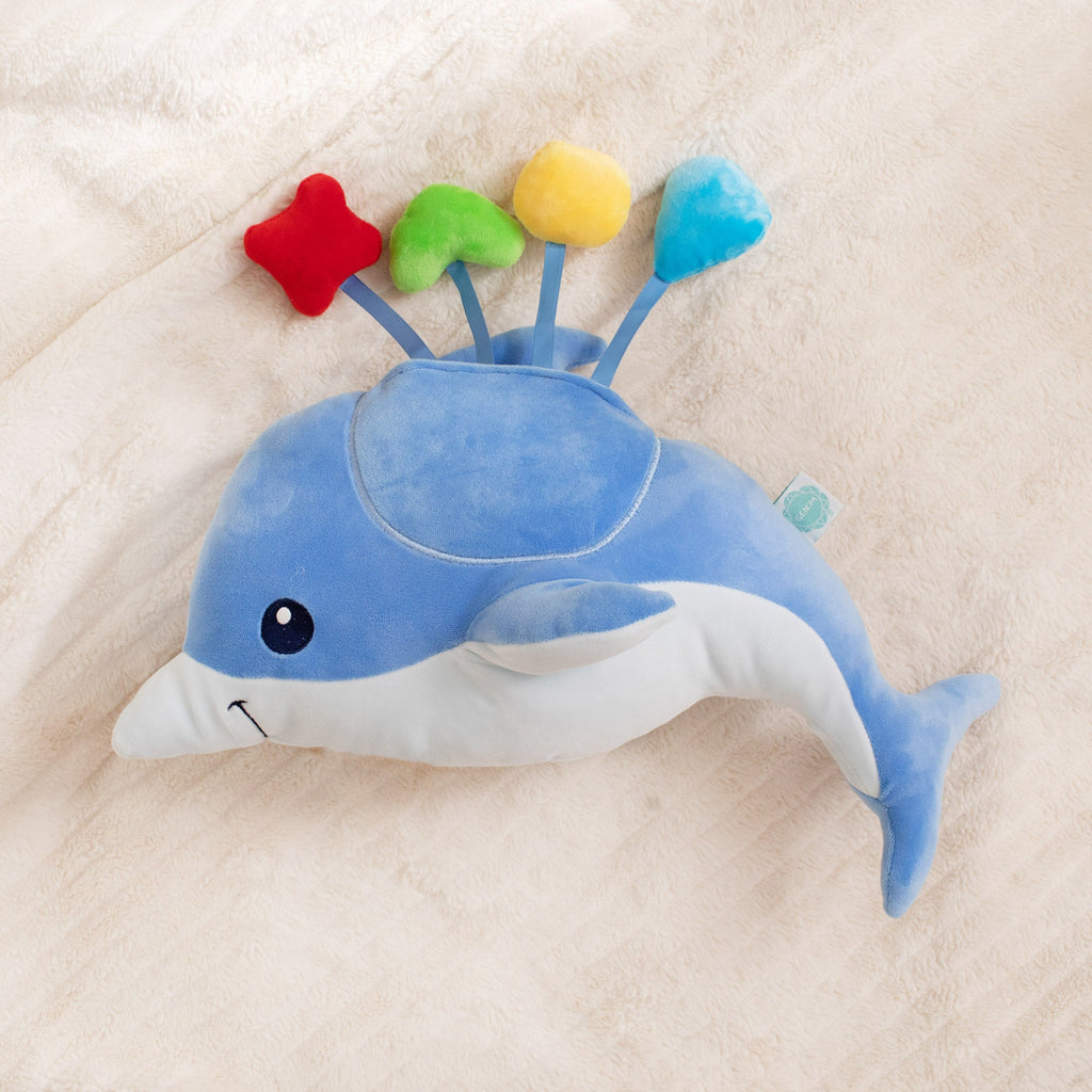 Blue dolphin plush toy on a beige blanket
