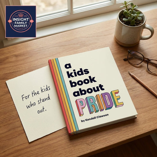 Children's book about pride on wooden desk with glasses, pencil, succulent, and note card.