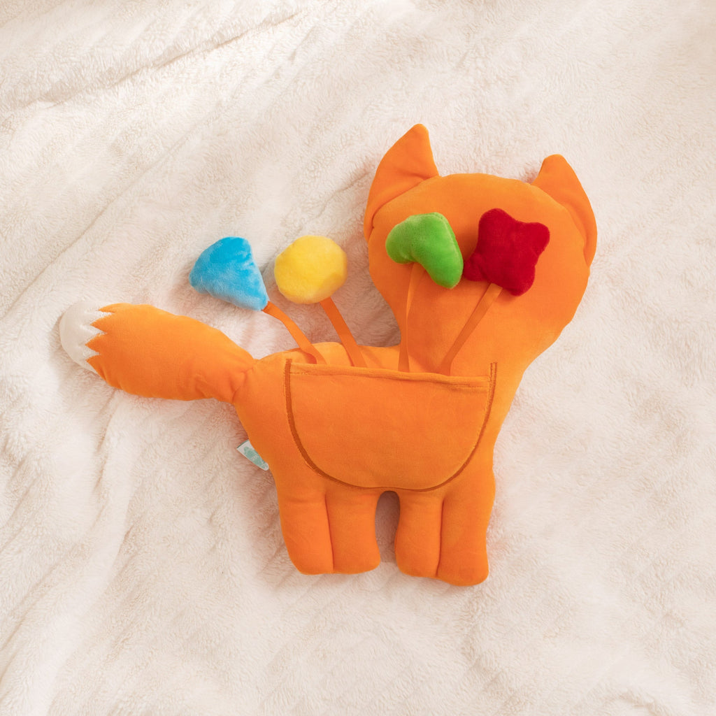 Plush fox toy with colorful accents on a soft surface