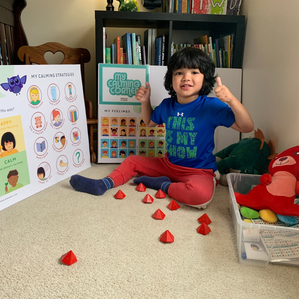 Child sitting on the floor with educational materials and toys in a room.