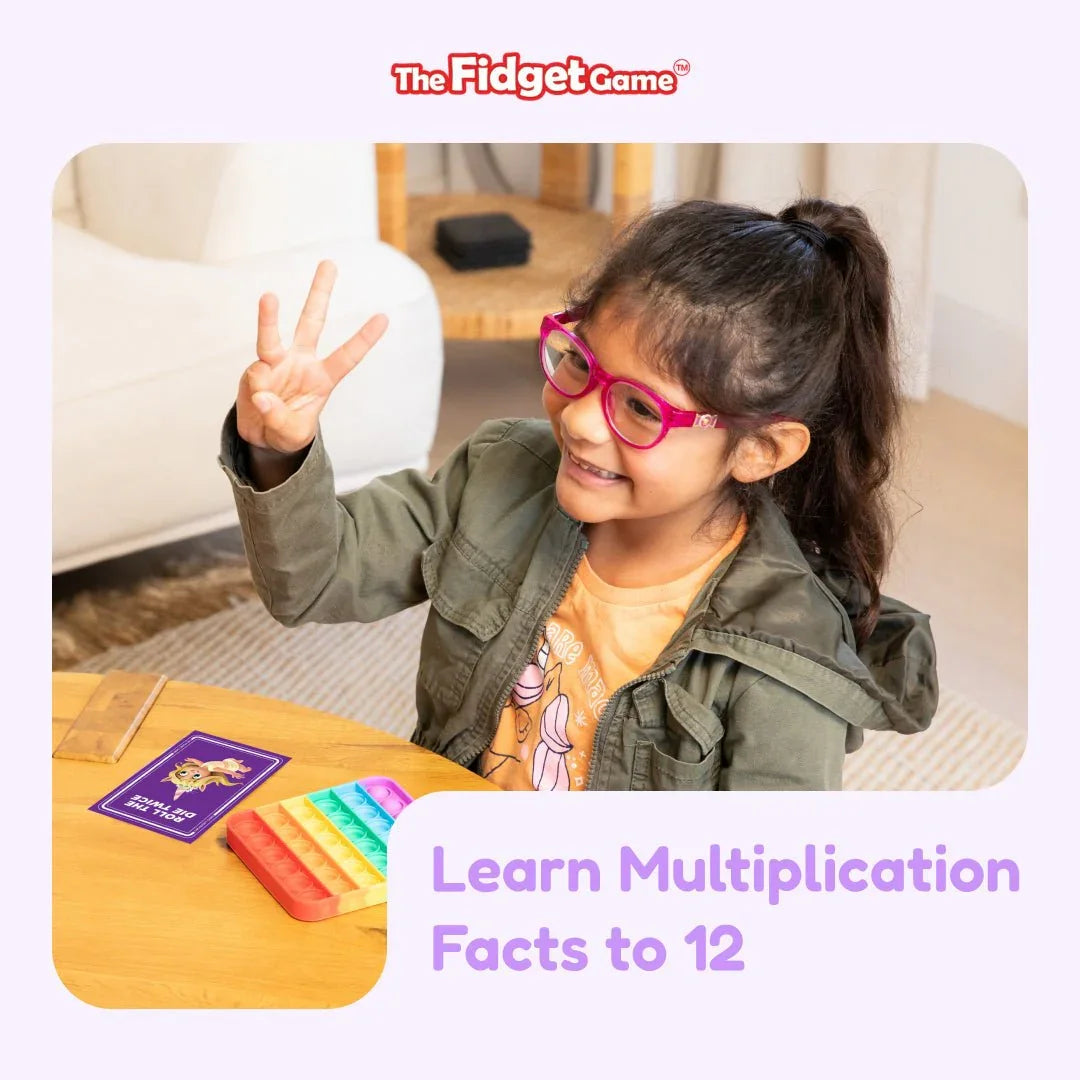 Child smiling while playing multiplication fidget game with math cards and pop-it toy.
