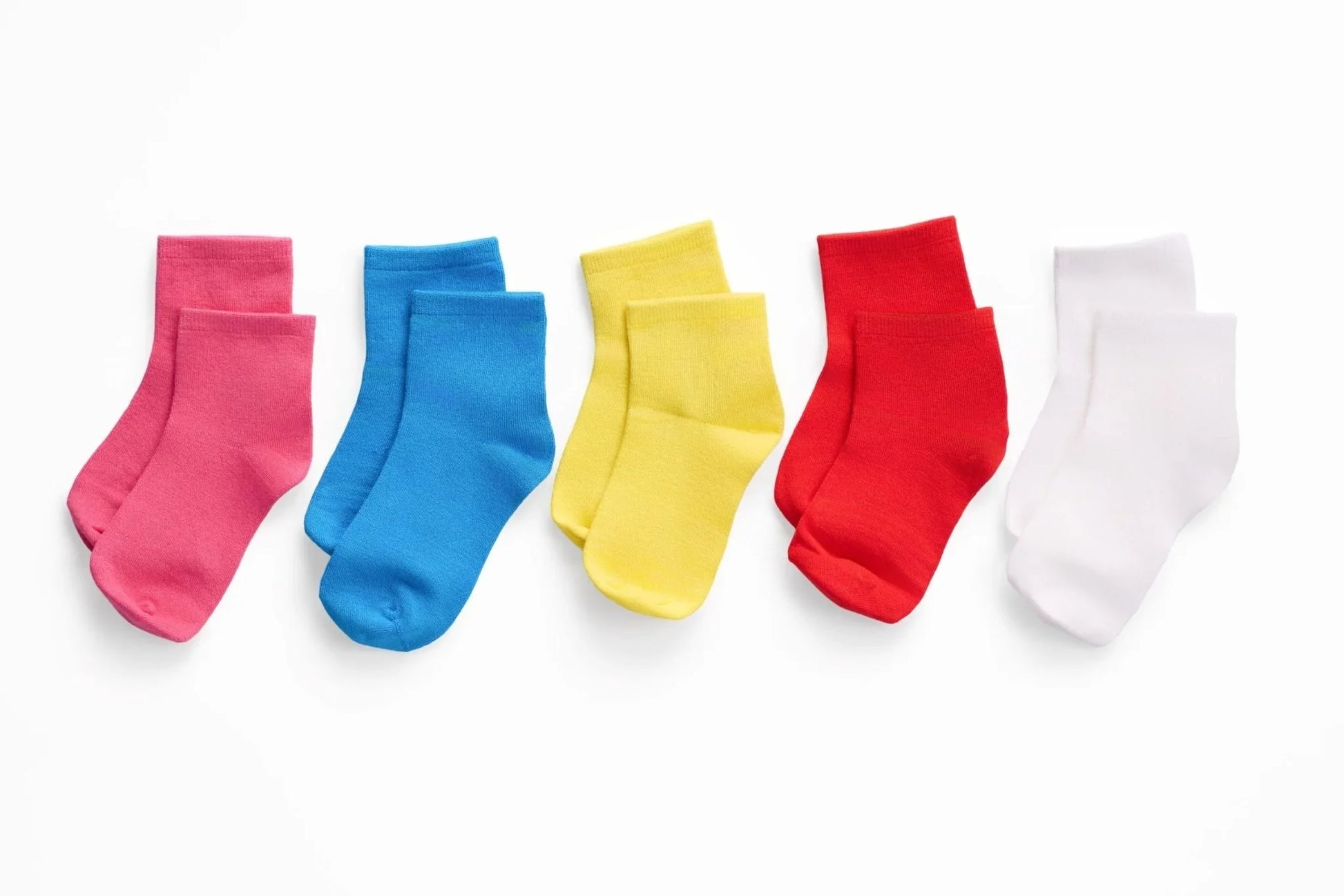 Five pairs of sensory-friendly ankle socks in pink, blue, yellow, red, and white on white background.