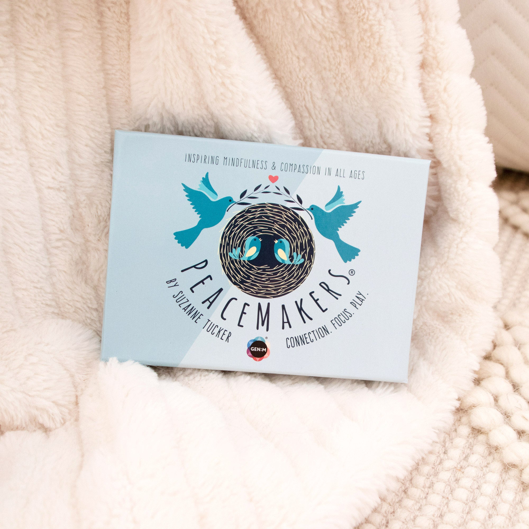 Card with 'Peacemakers' design on a soft beige fabric background