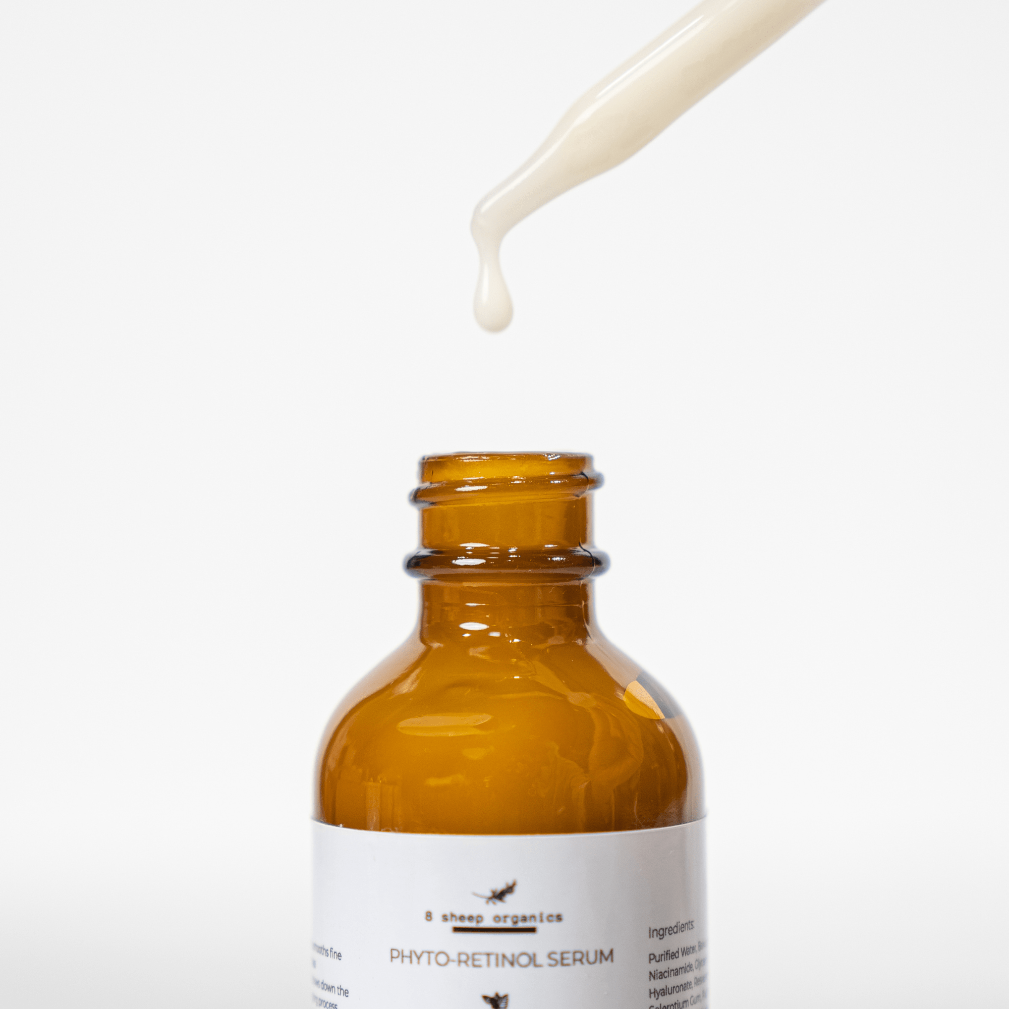 Amber glass bottle of phyto-retinol serum with a dropper on a white background