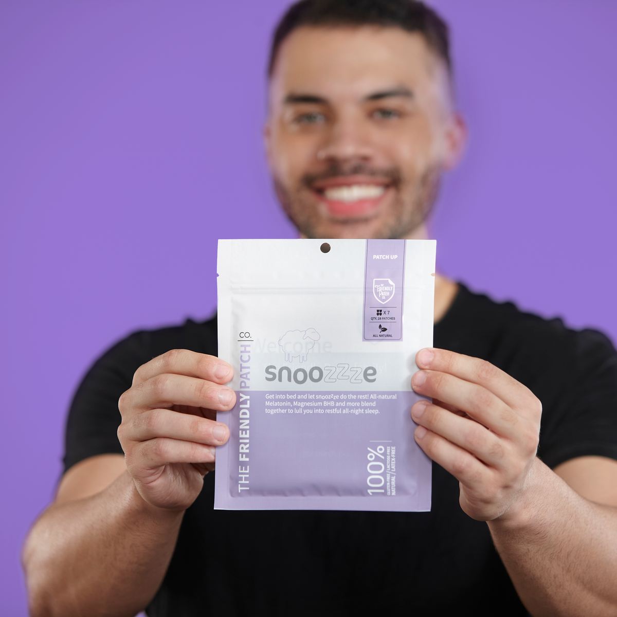 Man holding a purple package with text against a purple background