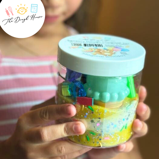 Person holding a jar of colorful slime with 'The Dough House' logo.
